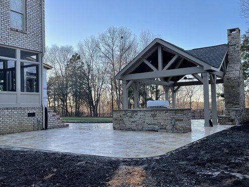 Stone outdoor kitchen pavilion with a paver patio